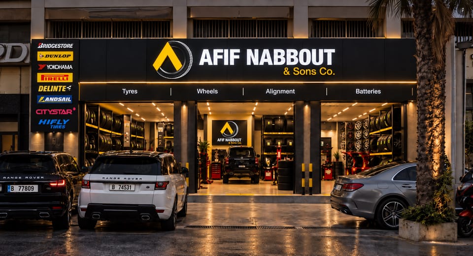 Afif Nabbout & Sons Co. branch in Tripoli at night, with its sign lit, a brand pylon on the left and cars parked outside