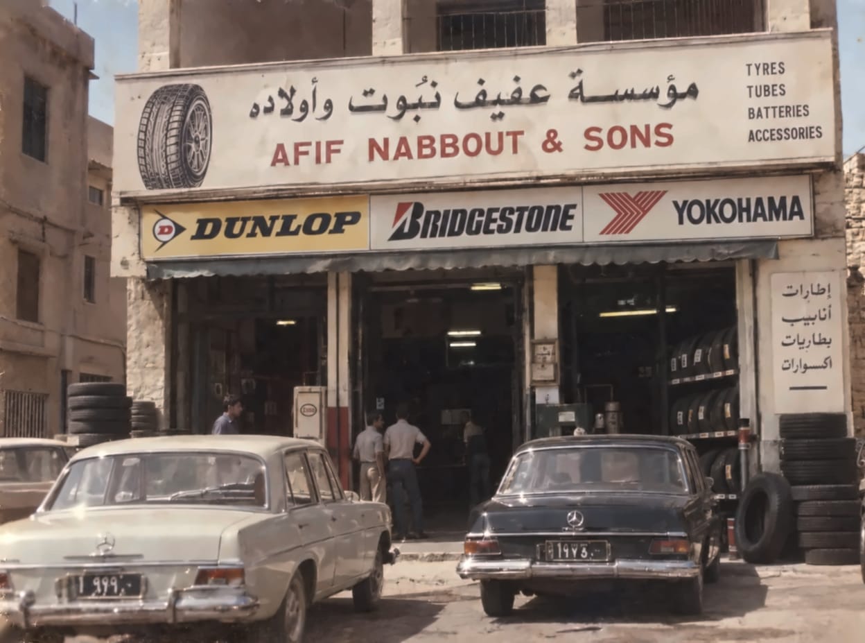 The first Afif Nabbout & Sons shop, opened in 1952, with its Arabic and English sign, Dunlop, Bridgestone and Yokohama boards and two Mercedes cars parked outside